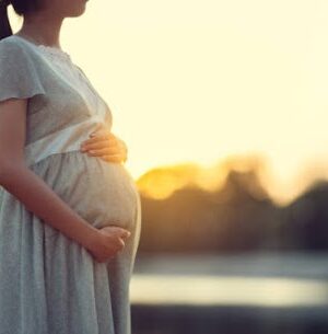 Pregnant woman walks in the park she feels relaxed