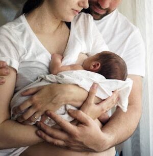 Father and mother with a newborn son. New young multi-generation family.